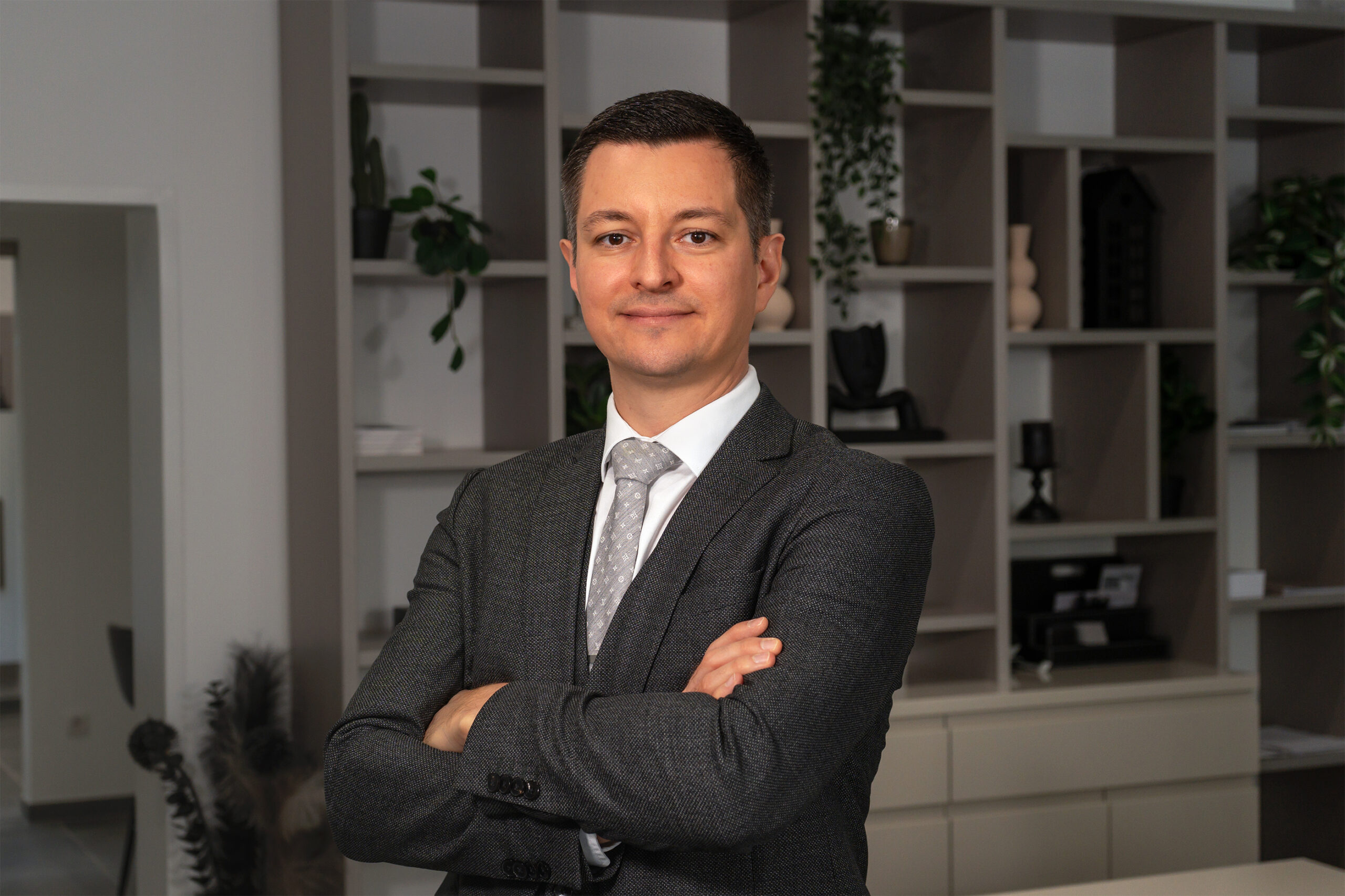 David Deindl, Gesch&auml;ftsf&uuml;hrer und Immobilienberater bei David Deindl Immobilien, l&auml;chelnd im B&uuml;ro