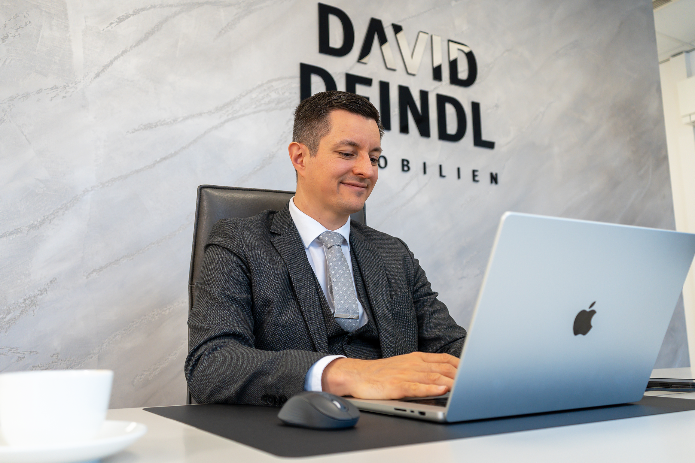 David Deindl, Gesch&auml;ftsf&uuml;hrer und Immobilienberater bei David Deindl Immobilien, arbeitet auf Laptop